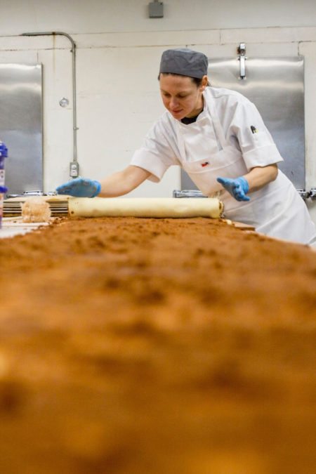 Amy Hughes rolls cinnamon rolls on Friday, Feb. 23, 2018 at Crust Bakery in Fenton.